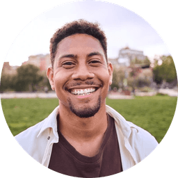 Smiling man with short hair wearing a light shirt outdoors in a park
